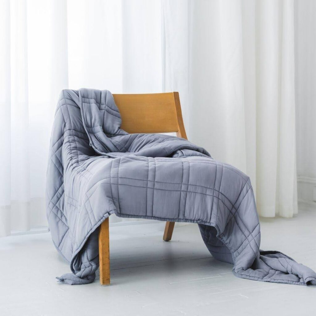 Comma bamboo weighted blanket draped over a chair