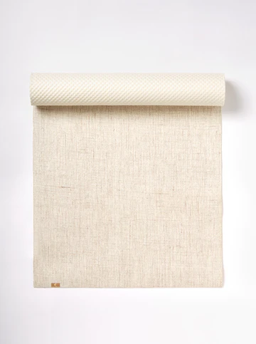 A partially rolled up beige jute yoga mat from ecoYoga