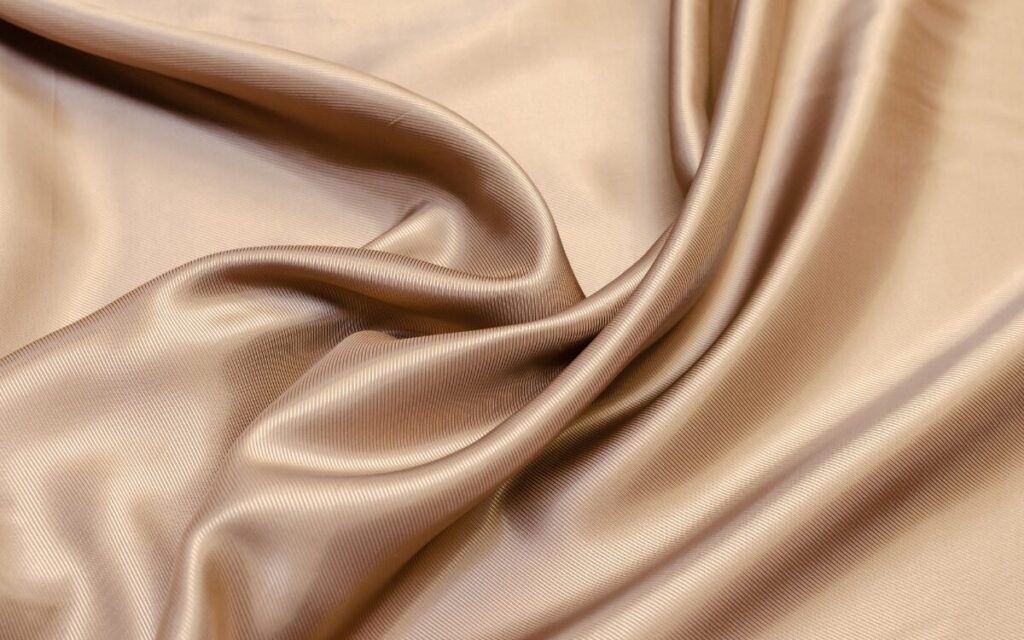 A close up of bronze or gold viscose material