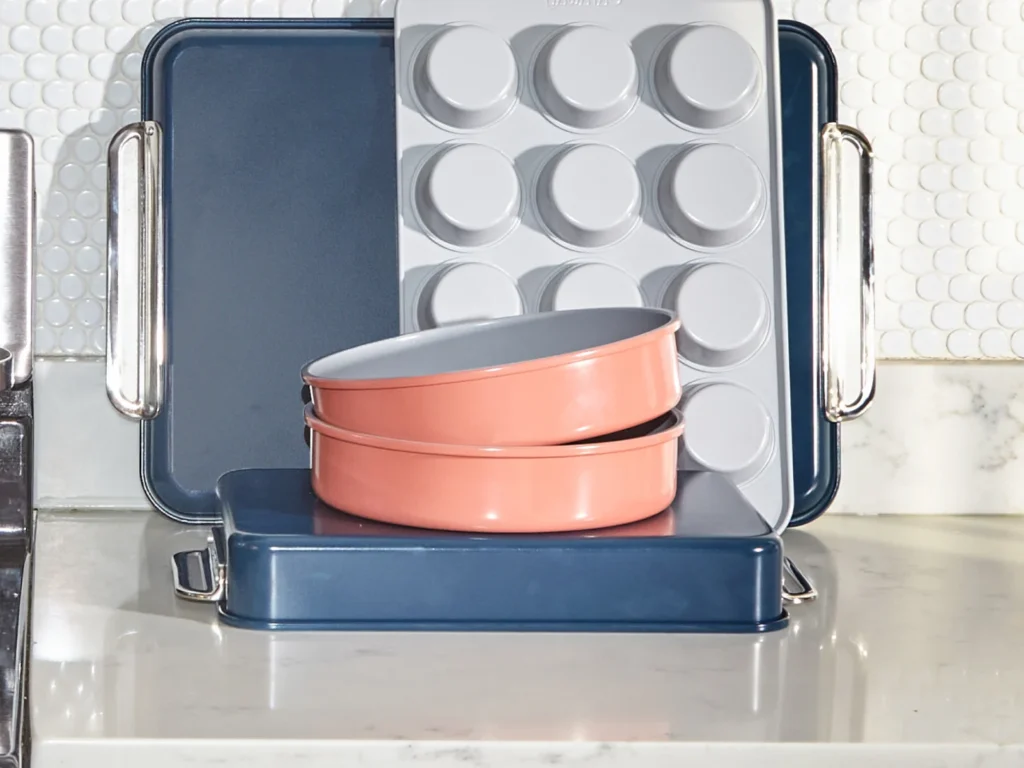 Pink and blue coated ceramic bakeware from the brand Caraway sitting on a counter