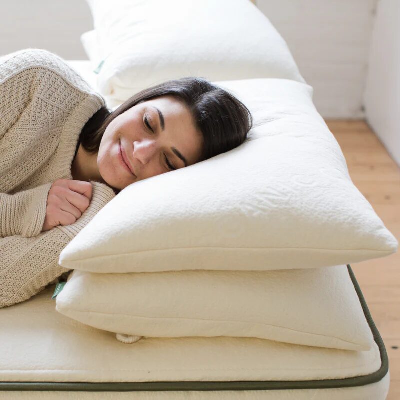 A woman sleeping atop a pair of OEKO-TEX pillows