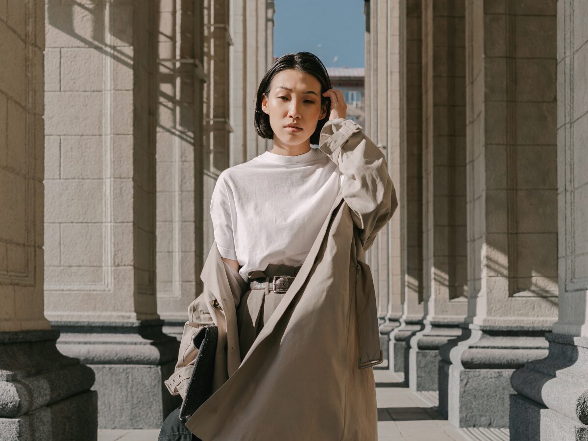 A woman wears a fashionable, professional Uniqlo layered beige and white outfit.