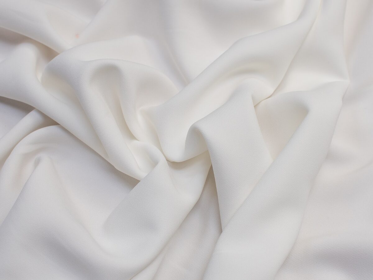 A bunched-up pile of off-white rayon cupro fabric