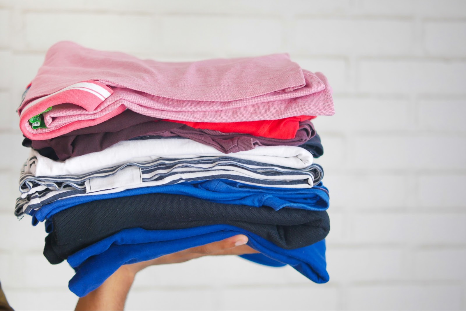 A person holding a pile of folded laundry